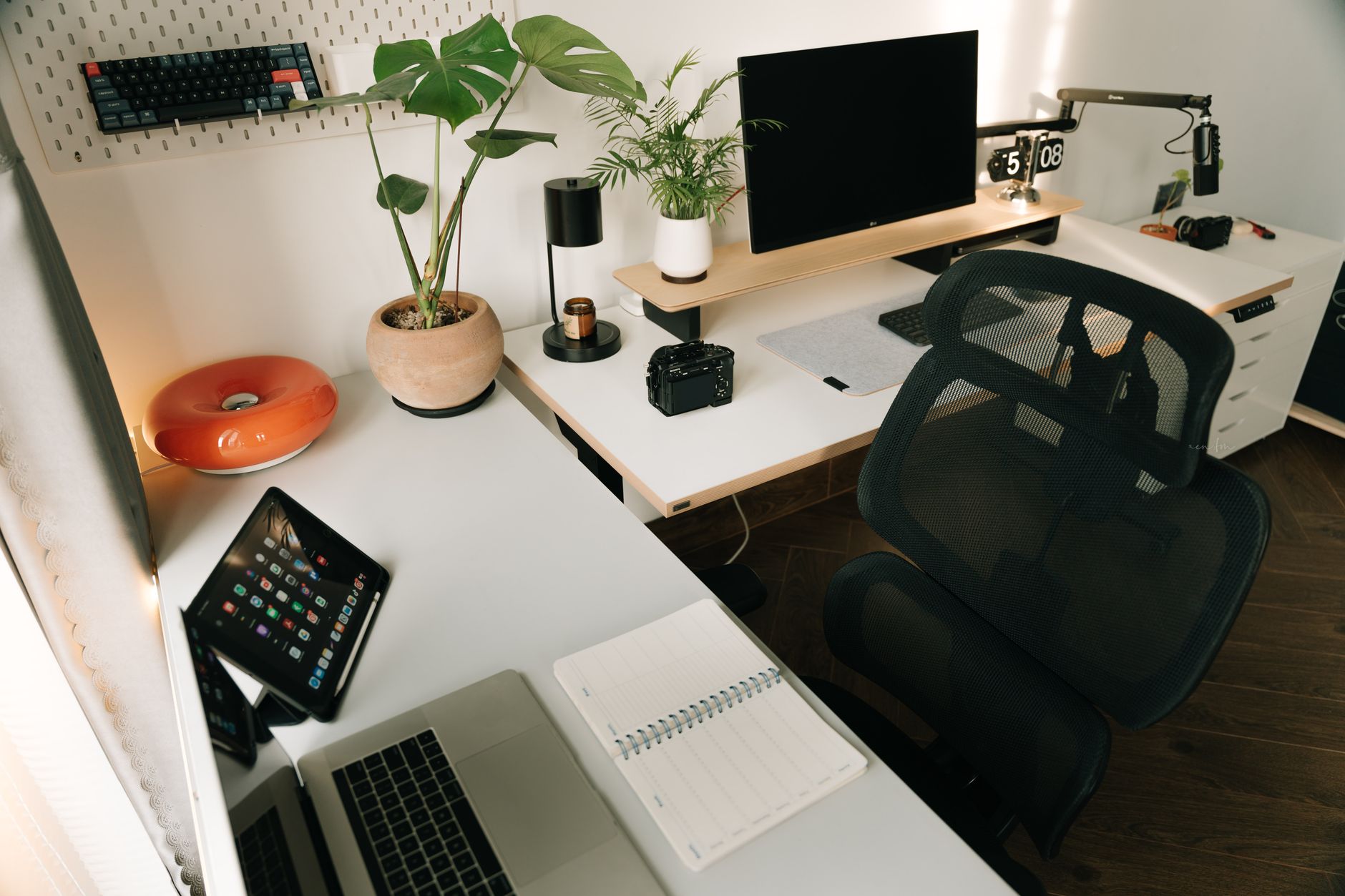 A bamboo top standing desk with a monitor and keyboard in a home office.