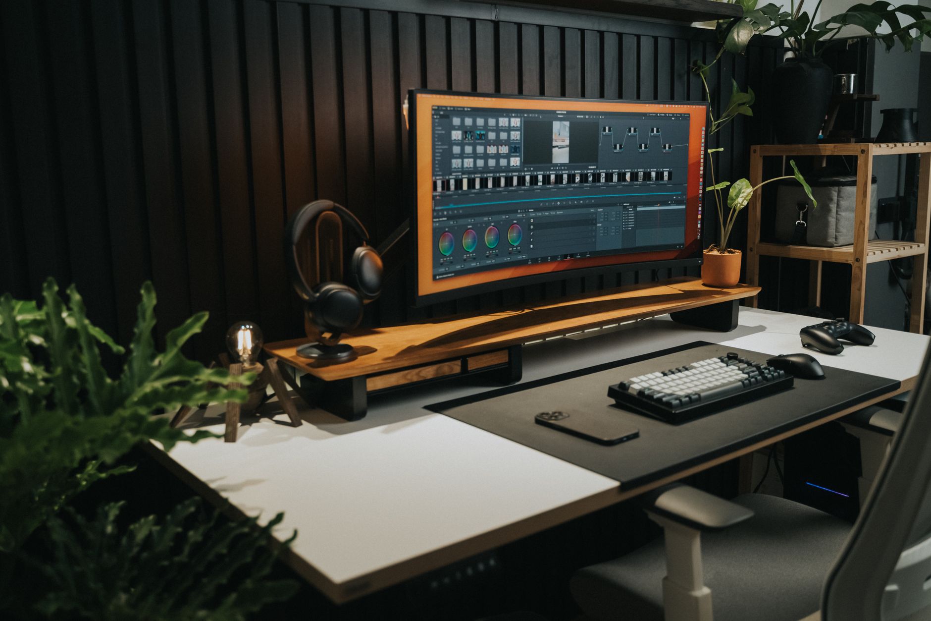 Bamboo electric standing desk with a monitor, keyboard, and desk plant in a bright home office