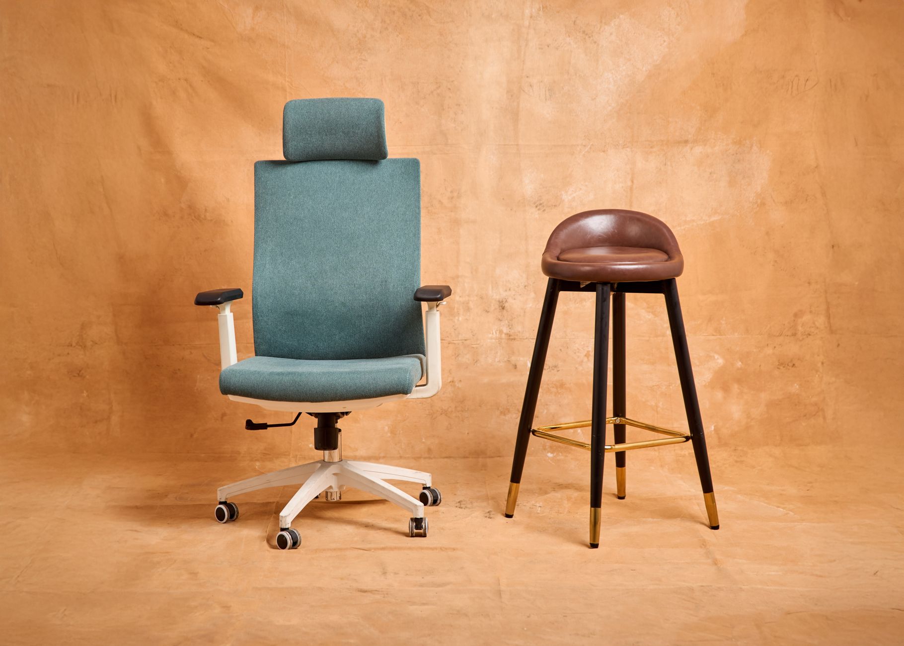 a person sitting in an office chair adjusting the seat height lever in a home office